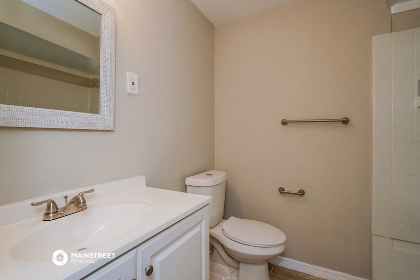 a bathroom with a toilet and a sink and a mirror