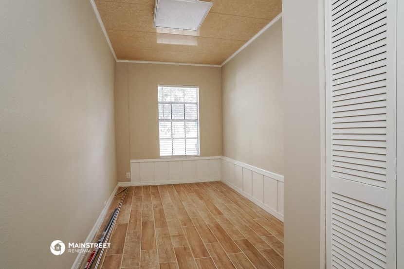 an empty room with wooden floors and a window