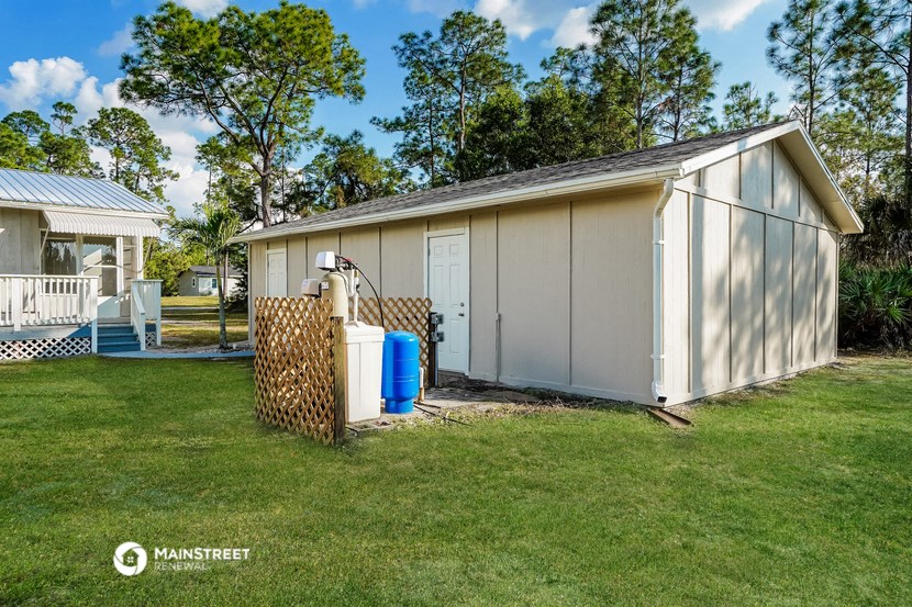 a small backyard shed with a water pump and a radiator on the grass