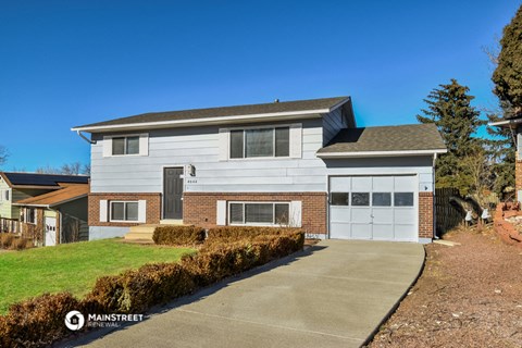 a white and brick house with a white garage door