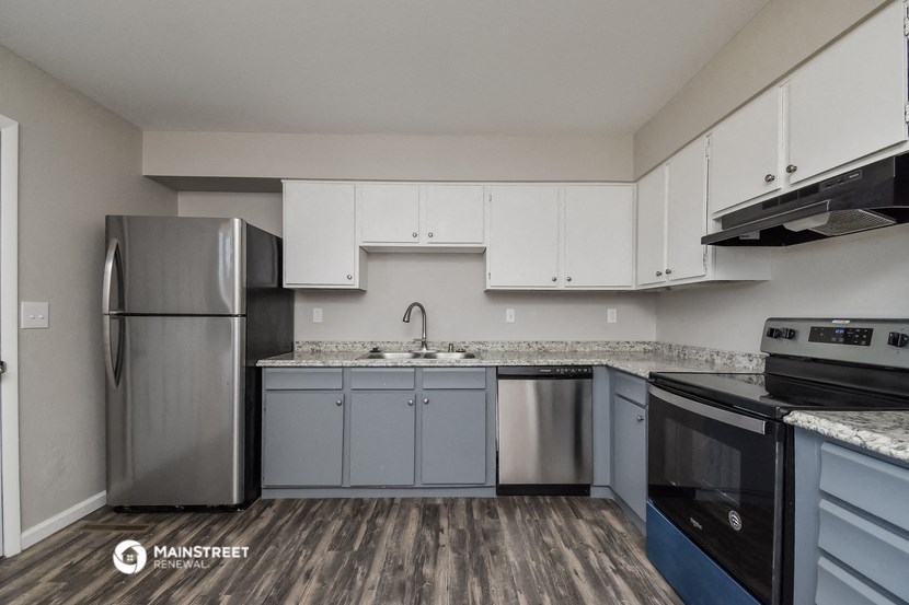 an empty kitchen with stainless steel appliances and white cabinets