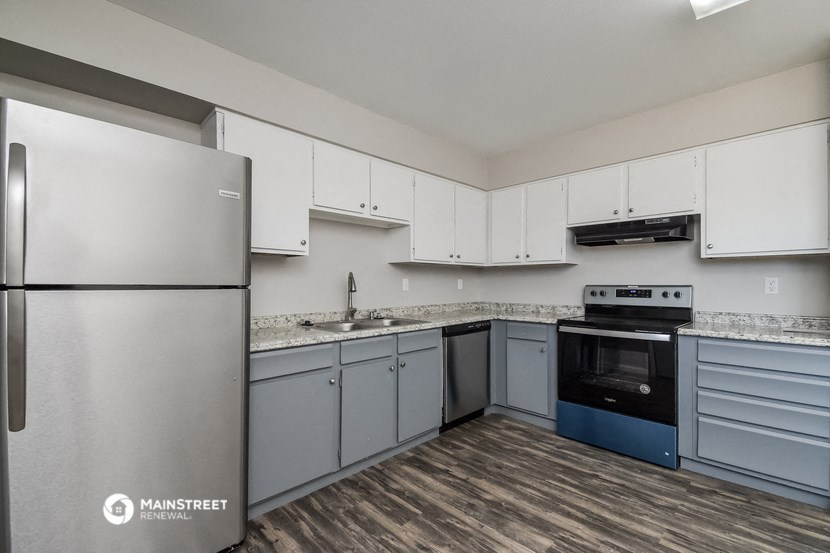 a kitchen with white cabinets and stainless steel appliances and a refrigerator