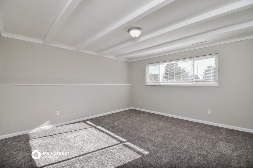 an empty room with carpet and a window