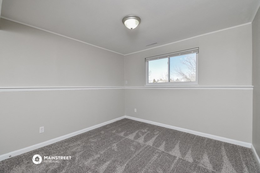 an empty room with carpet and a window