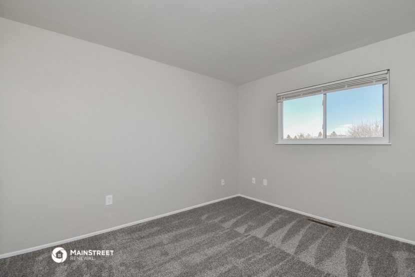 an empty room with carpet and a window