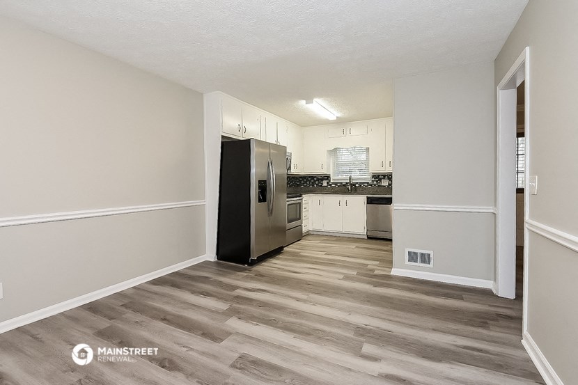 an empty kitchen with a stainless steel refrigerator