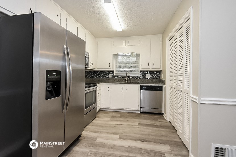 a kitchen with stainless steel appliances and white cabinets