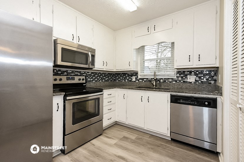 a kitchen with stainless steel appliances and white cabinets