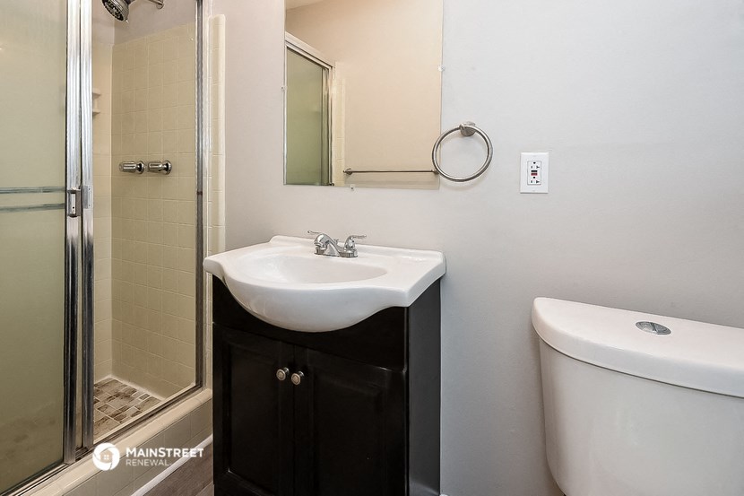 a bathroom with a sink and a shower and a toilet