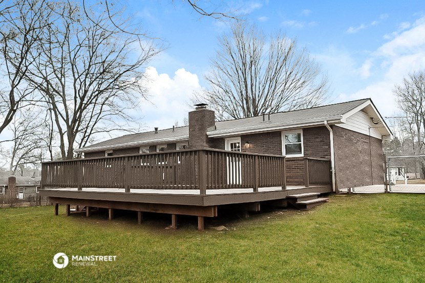 a view of a house with a deck in front of it