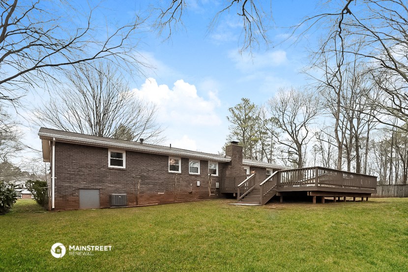 a brick house with a deck and a large yard