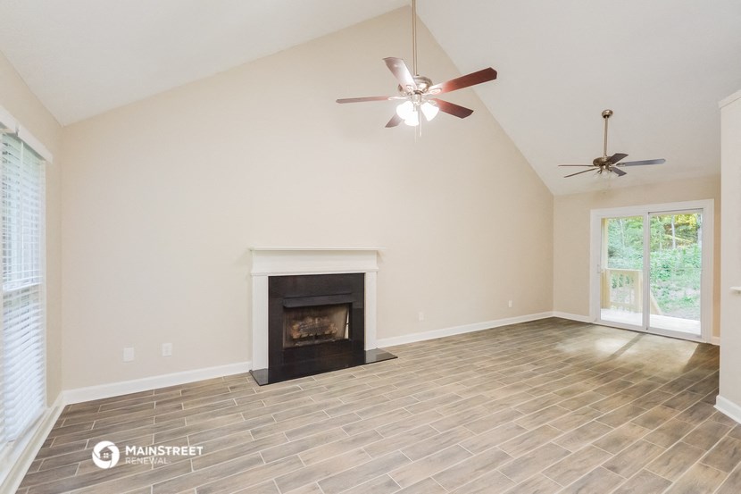 the living room with fireplace and ceiling fan