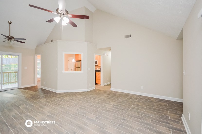 the living room and dining room with a ceiling fan