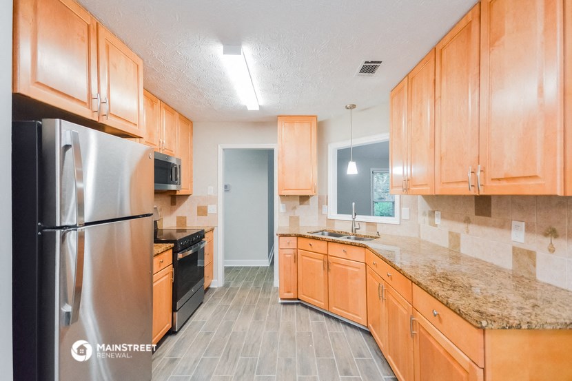 a kitchen with wooden cabinets and stainless steel appliances