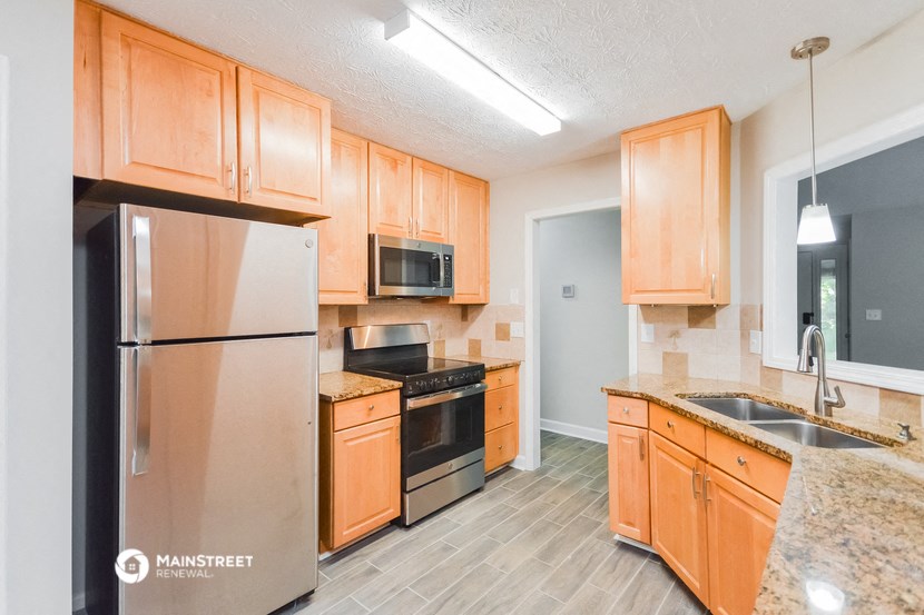 a kitchen with wooden cabinets and stainless steel appliances