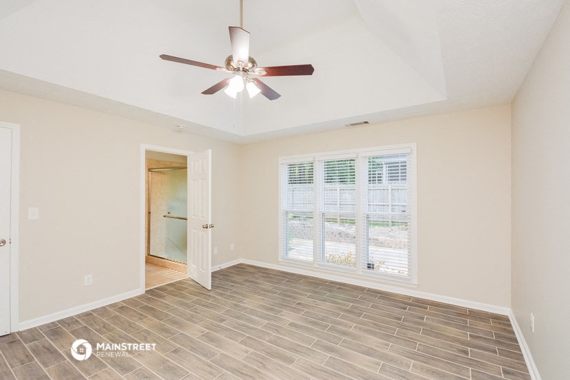 a living room with a ceiling fan and a window