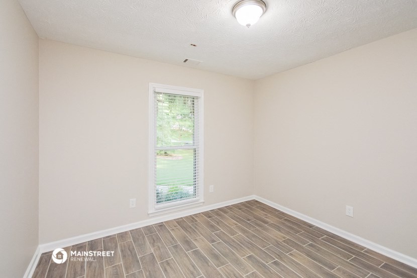 the spacious living room with vinyl flooring and a window