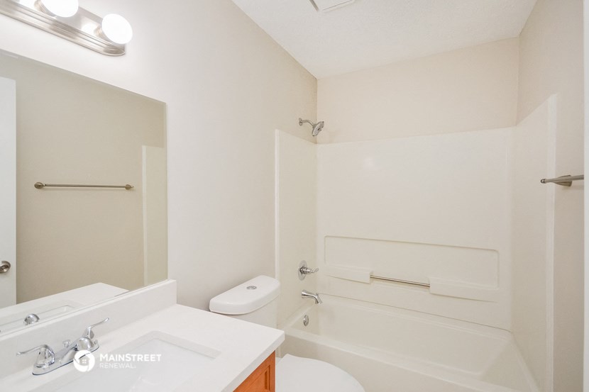a bathroom with a white toilet and a tub and a sink