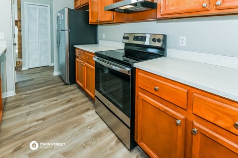 a kitchen with wooden cabinets and a stove and a refrigerator
