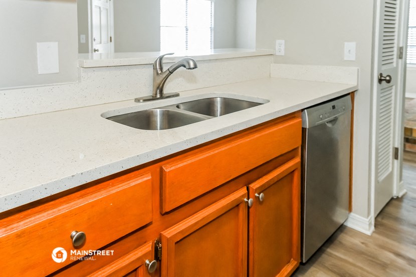 a kitchen with a sink and a stainless steel dishwasher