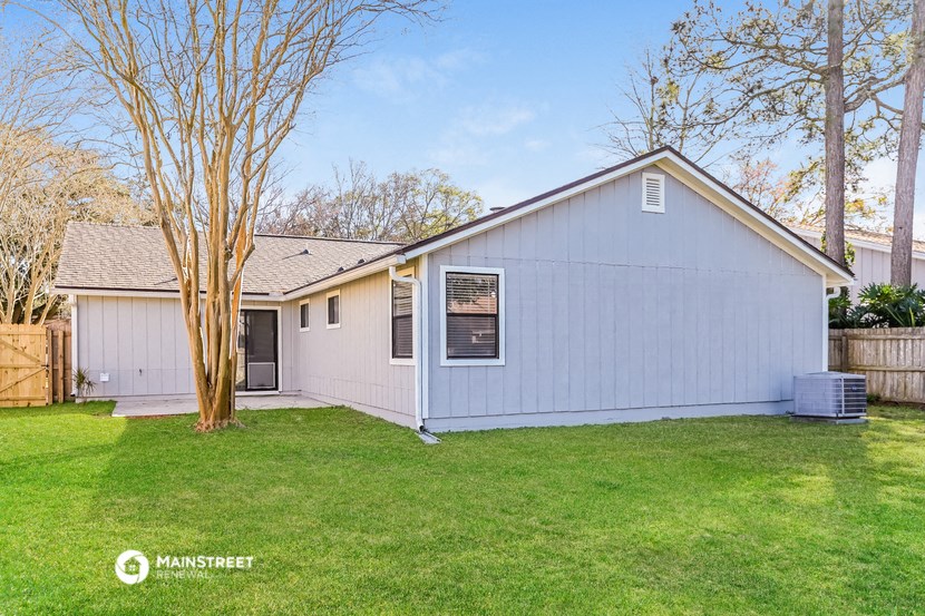 a blue and white house with a yard and a tree
