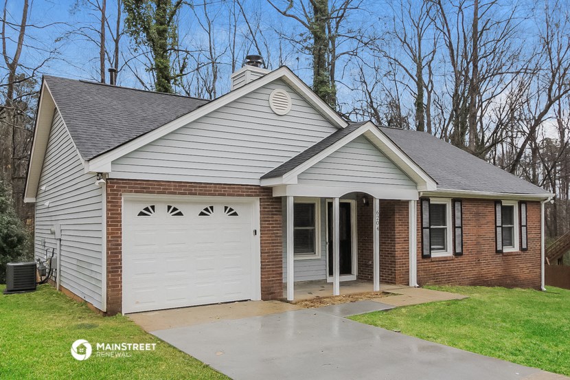 the front of a brick house with a white garage door