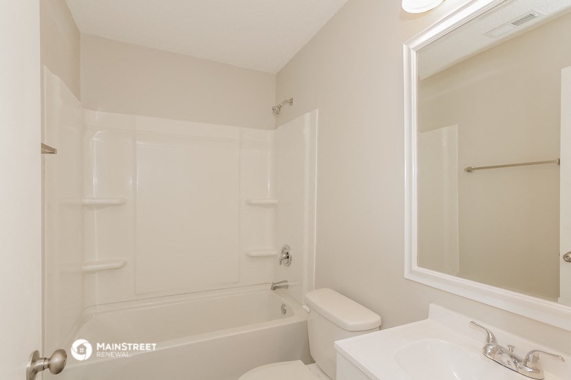 a white bathroom with a tub and a sink and a toilet