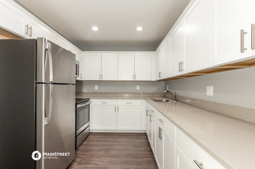 a white kitchen with stainless steel appliances and white cabinets