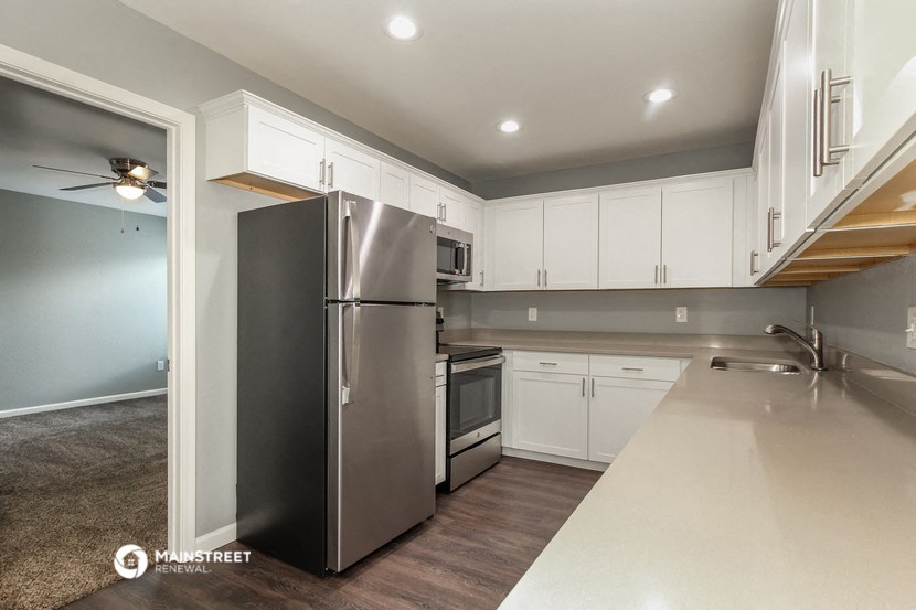 a kitchen with white cabinets and a stainless steel refrigerator
