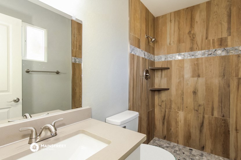 a bathroom with a shower toilet and sink and a mirror