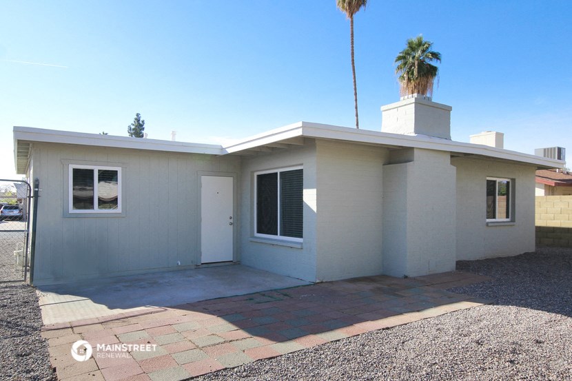 a small white house with a palm tree in the background