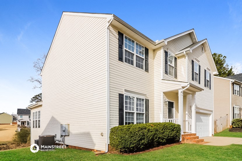 a white house with white siding and green grass