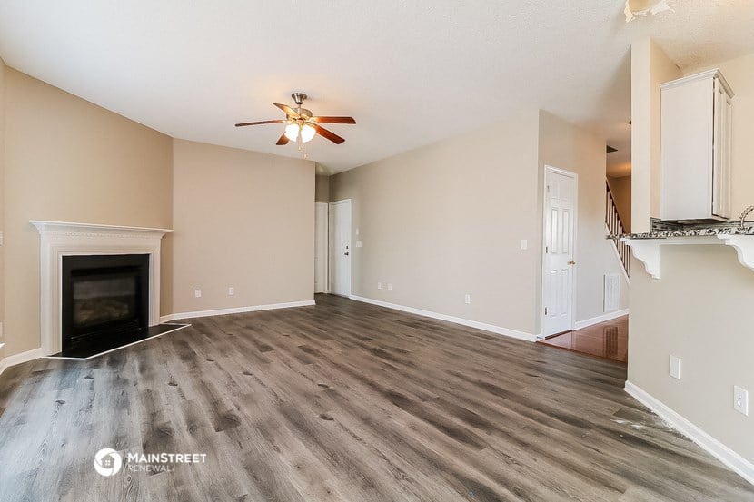 a living room with a fireplace and a ceiling fan