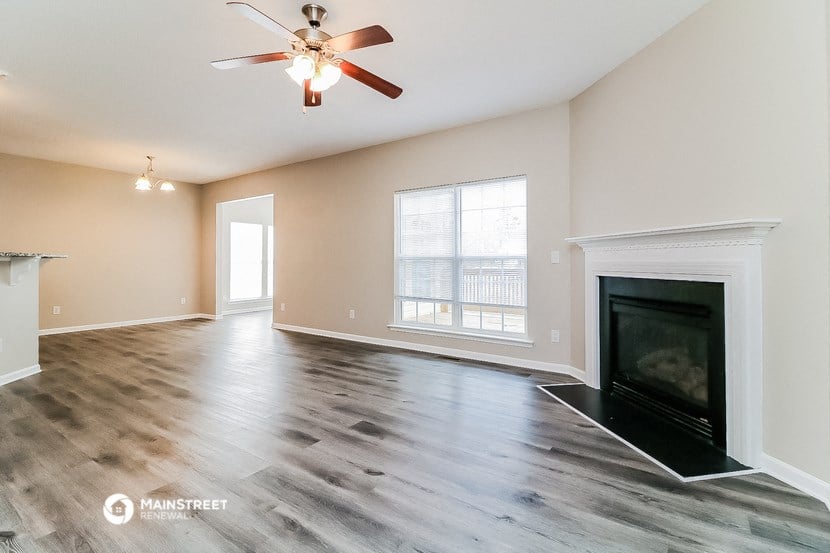 a living room with a fireplace and a ceiling fan