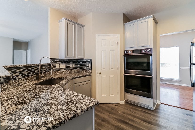a kitchen with granite counter tops and a stainless steel oven