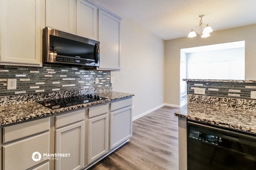 a kitchen with granite counter tops and a stove and a microwave
