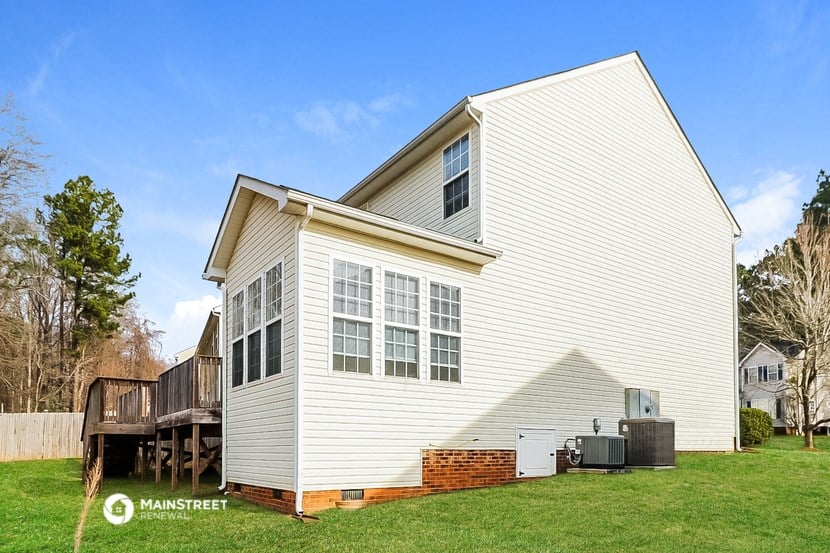 a white house with a backyard and a deck