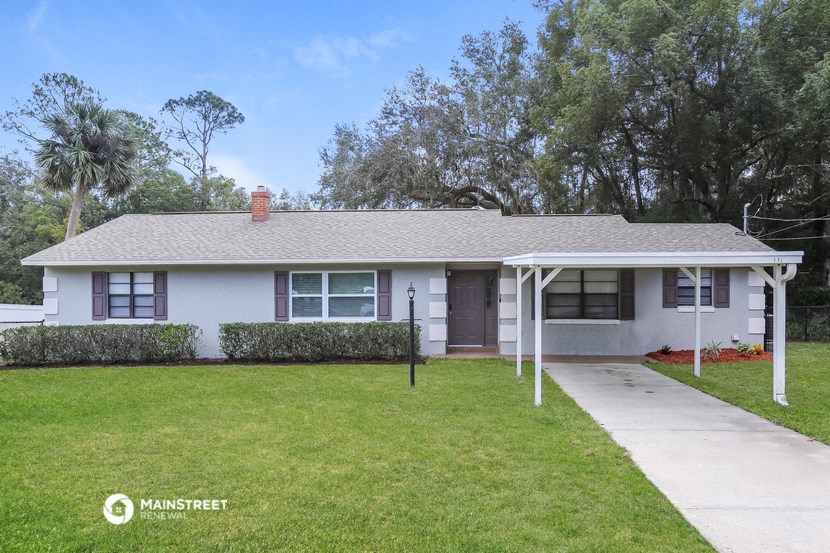 a small white house with a yard and a sidewalk