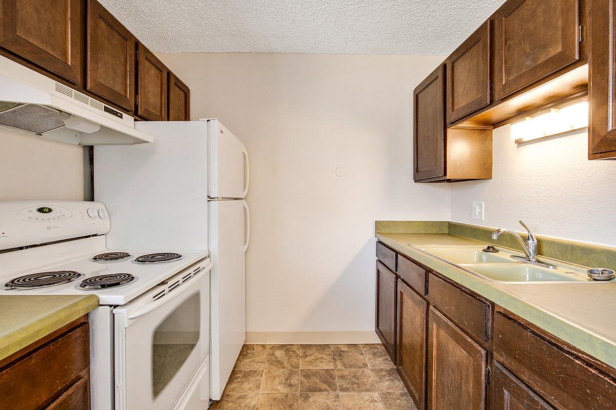 a kitchen with a stove refrigerator and sink