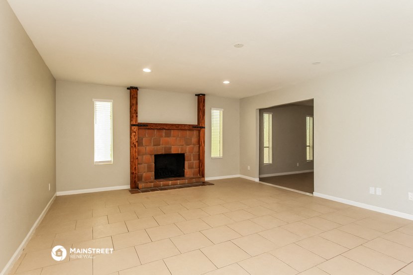 the spacious living room with a fireplace and tiled flooring