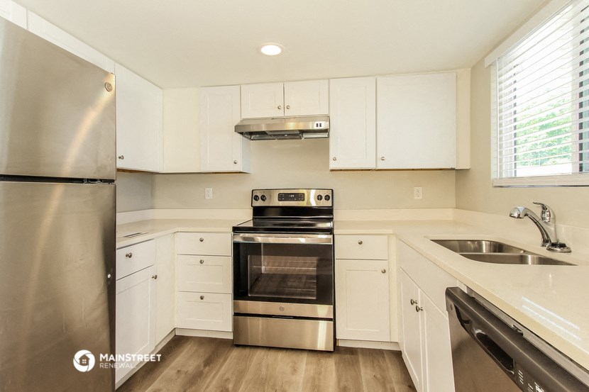 a kitchen with white cabinets and stainless steel appliances