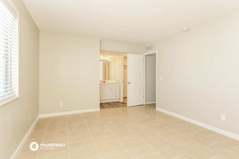 the spacious living room and bathroom of this renovated home