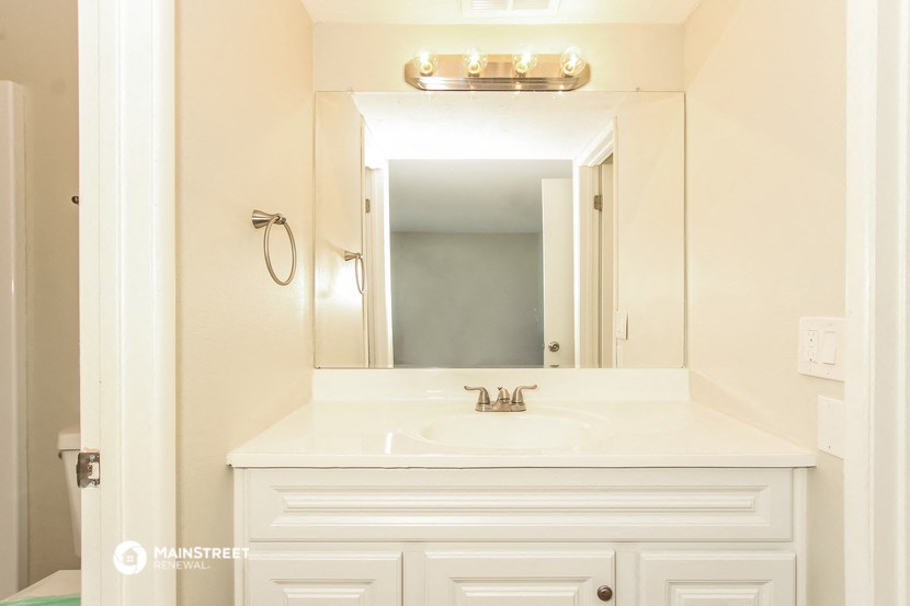 a white bathroom with a sink and a mirror