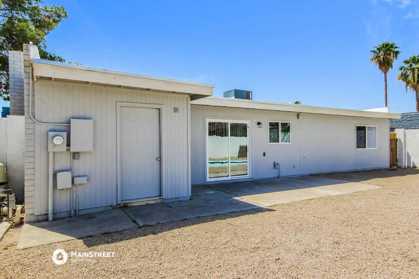 a white building with a white door and a palm tree
