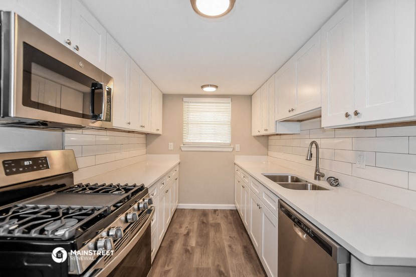 a modern kitchen with white cabinets and stainless steel appliances