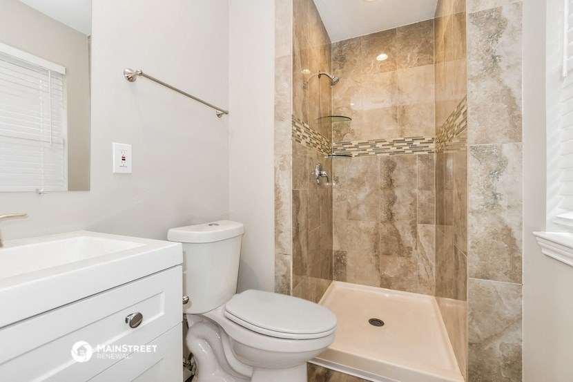 a bathroom with a toilet and a shower and a sink