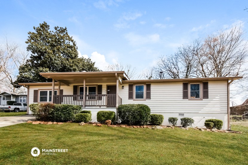 a white house with a porch and a lawn