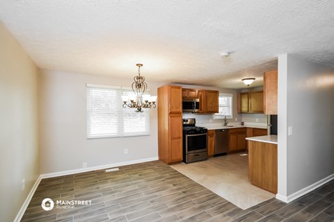 a kitchen with wood flooring and wooden cabinets