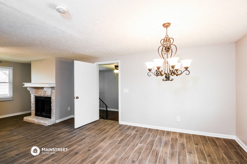a living room with a fireplace and a chandelier