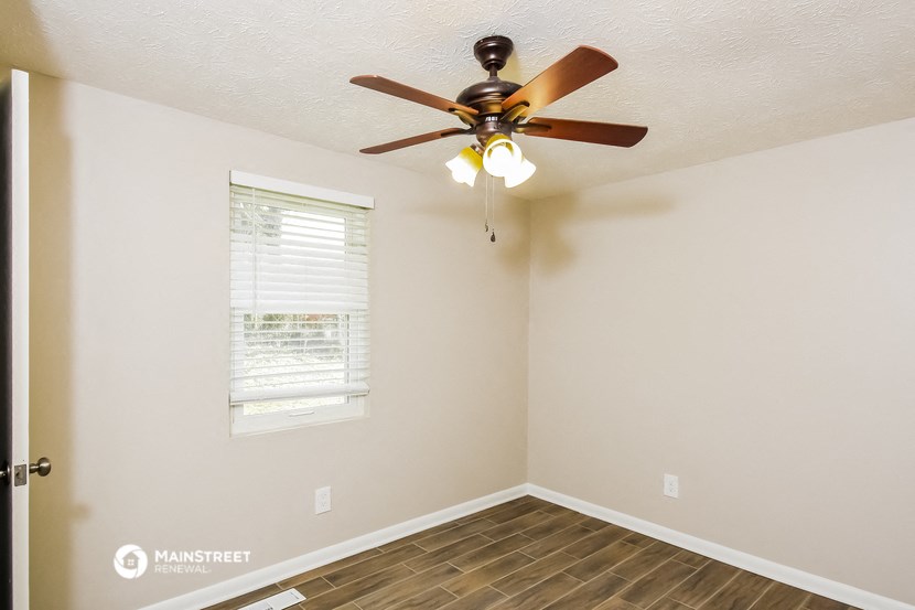 a bedroom with a ceiling fan and a window